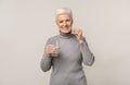 Smiling senior woman taking pills and holding glass of water Royalty Free Stock Photo