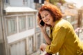 Smiling Senior Woman Talking On Cellphone While Standing On Balcony At Home Royalty Free Stock Photo