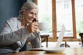 Smiling senior woman talking on mobile phone while drinking coffee Royalty Free Stock Photo