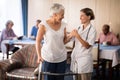 Smiling senior woman with walker looking at female doctor