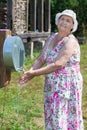 Smiling senior woman washing her hands outdoor Royalty Free Stock Photo