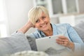 Smiling senior woman websurfing on tablet