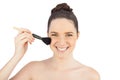Smiling sensual model using blusher brush Royalty Free Stock Photo