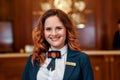 Smiling service. Close up of happy female receptionist worker in uniform looking at camera with a smile while standing Royalty Free Stock Photo