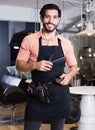 Smiling sexy worker man hairdresser in studio