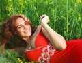 Smiling young woman lying in green grass Royalty Free Stock Photo