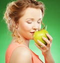 Smiling sharming woman with green apple over green background Royalty Free Stock Photo