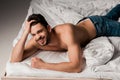 Shirtless bearded man in jeans lying Royalty Free Stock Photo