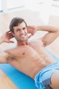 Smiling shirtless man doing sit ups in fitness studio Royalty Free Stock Photo