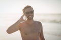 Smiling shirtless man talking on mobile phone at beach Royalty Free Stock Photo