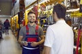 Smiling shop assistant at DIY store helping customer who is buying tools for home repairs Royalty Free Stock Photo