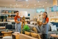 smiling shop assistants with a friend working to tidy up a store