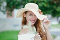 Smiling shy outdoors. Flirty woman looking at you camera touching pulling down her hat smiling shy holding herb flower in hand Royalty Free Stock Photo