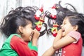 Smiling sisters decorating their hair with Christmas