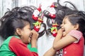 Smiling sisters decorating their hair with Christmas decorations