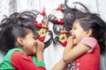 Smiling sisters decorating their hair with Christmas decorations