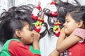 Smiling sisters decorating their hair with Christmas decorations