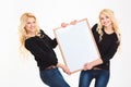 Smiling sisters twins holding blank board