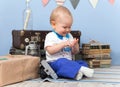 Smiling sitting little boy counts his fingers at home