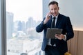 Smiling skilled businessman talking phone while looking at data. Ornamented. Royalty Free Stock Photo