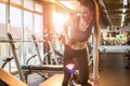 Smiling slim fit girl in sportswear lifting weights in gym Royalty Free Stock Photo