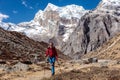 Smiling slim Hiker walking on grassy Footpath in high Mountains