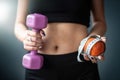 woman in holding apple and measuring tape and dumbbell standing  over gray background Royalty Free Stock Photo