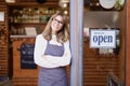 Smiling small business owner woman standing in the cafe doorway while waiting for her guest Royalty Free Stock Photo