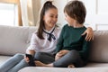 Happy siblings rest on sofa using smartphone Royalty Free Stock Photo