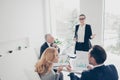 Smiling, smart, beautiful woman in suit, glasses, spectacles present her plan and ideas to partners who sitting Royalty Free Stock Photo