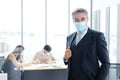 Smiling and Smart Caucasian businessman in black suit and asian staff and teamwork wearing masks prevent covid 19 virus at office