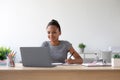 Smiling smart young african american girl pupil with headphones study at home with laptop