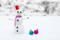 Smiling snowman and Christmas decorations in the forest during a snowfall. Picturesque winter landscape.