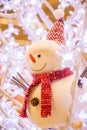 Smiling snowman with red hat and muffler among ice crystals