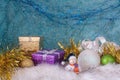 A smiling snowman on a white fur base next to Christmas balls and gift boxes. Royalty Free Stock Photo