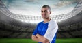 Smiling soccer player with arms crossed at stadium