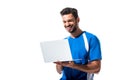 Smiling soccer player using laptop