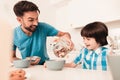 Smiling Son and Father Have Breakfast in Kitchen Royalty Free Stock Photo