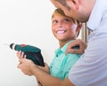Smiling son helping proud father to drill Royalty Free Stock Photo