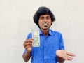 holding a 500 rupee note in one hand and showing something in his other hand. White background Royalty Free Stock Photo