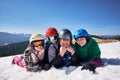 Happy smiling family on skis and snowboard in deep snow on background of winter mountains. Royalty Free Stock Photo