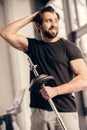 smiling sportsman holding iron bar and touching hair