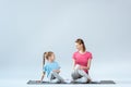 Smiling sporty mother and daughter practicing gomukhasana yoga pose Royalty Free Stock Photo