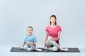 Smiling sporty mother and daughter practicing yoga, gomukhasana pose Royalty Free Stock Photo