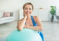 Smiling Sporty Woman Exercising Leaning On Fitness Ball At Home Royalty Free Stock Photo