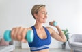 Smiling Sporty Woman Exercising With Two Dumbbells At Home Royalty Free Stock Photo