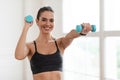 Smiling Sporty Woman Exercising With Two Dumbbells And Posing Royalty Free Stock Photo