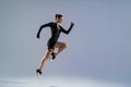 Smiling sporty woman running in Mid-Air exercising during cardio workout over studio background Royalty Free Stock Photo