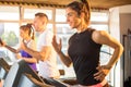 Smiling sporty woman running on a treadmill in gym. Royalty Free Stock Photo