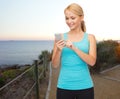 Smiling sporty woman with smartphone outdoors